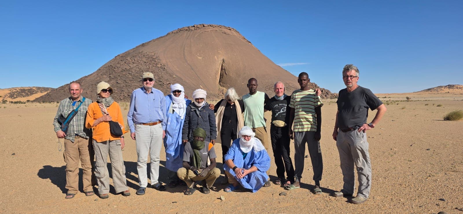 Founder Ely Cheikh in a light-blue robe with Sahara Nomads guests and team in the Adrar